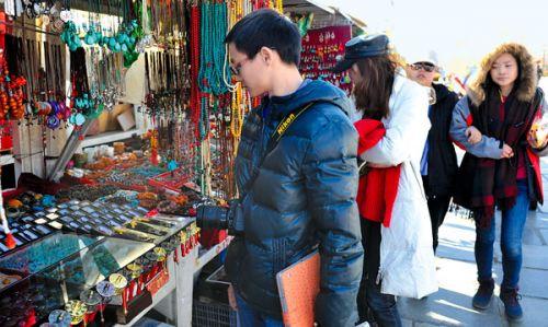 图为近日，来自广东的游客在选购纪念品。