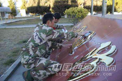 图为退伍老兵最后一次清理“中国边防”四字