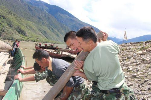 图为官兵帮助船主挪动搁浅船只