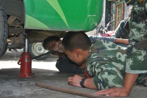 图为官兵与车主一起更换备胎