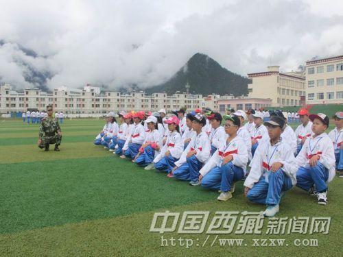 图为官兵教参训学生下蹲动作