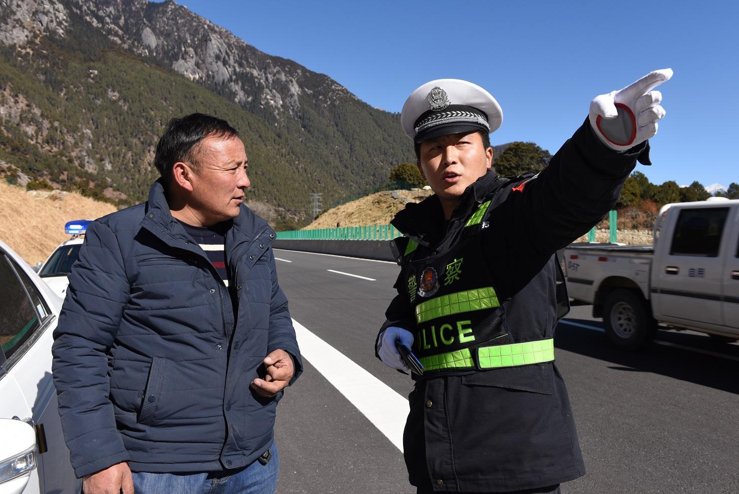 图为高速交警为驾驶员指路。.JPG