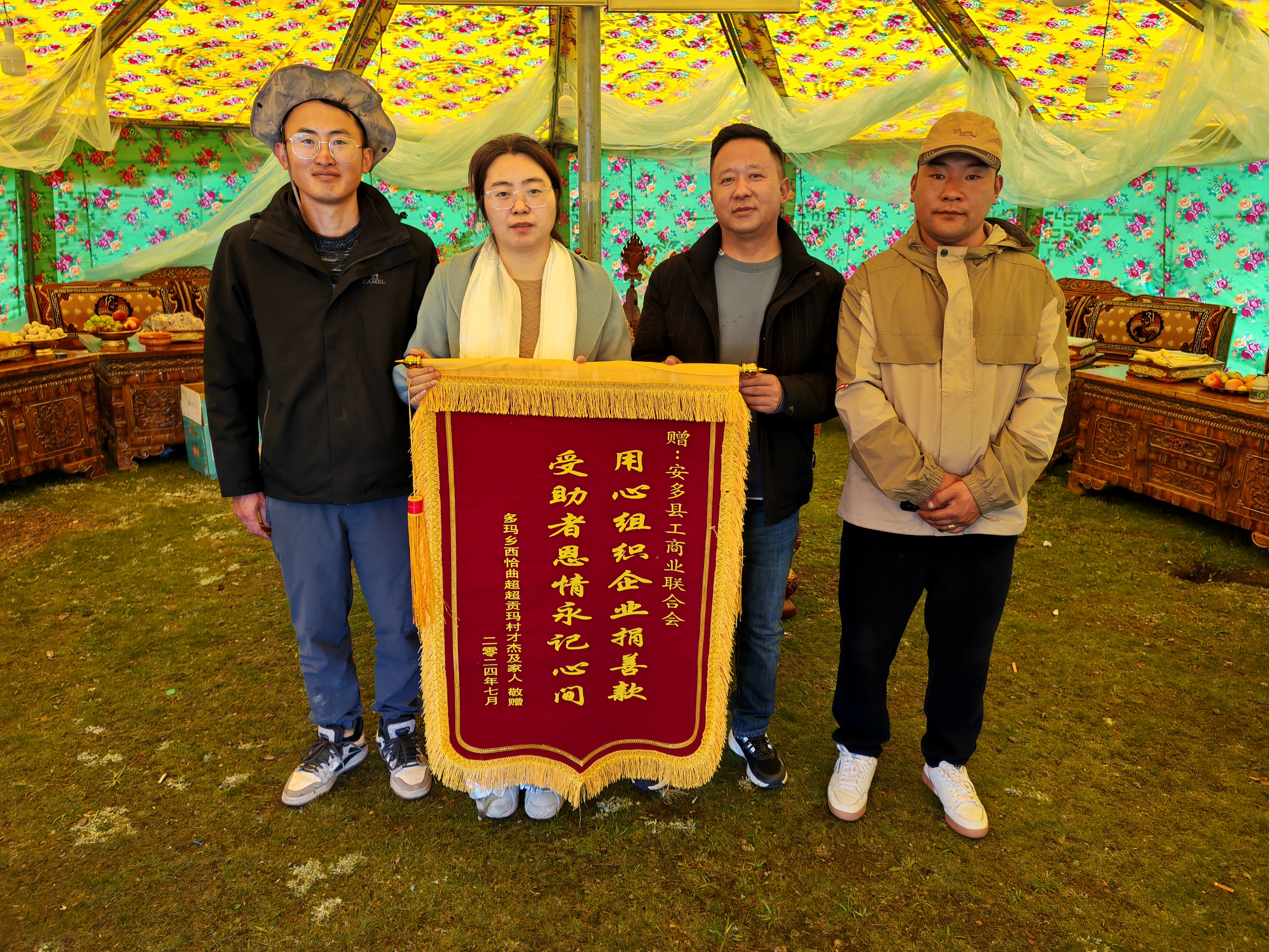 图为多玛乡人大主席多吉次旦（右二）带领驻村工作队向县委统战部副部长、工商联主席周利君（左二）敬献锦旗.jpg