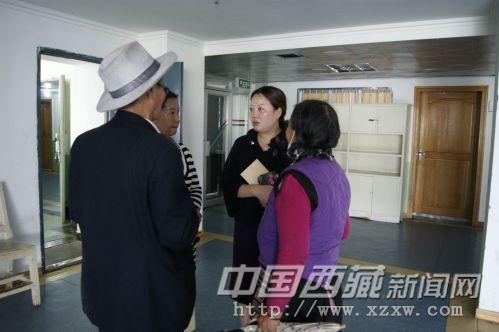 自治区福彩中心主任唐慧（右二）正在向贡嘎索朗的家人了解情况