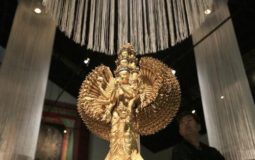 7月11日，在日本北海道近代美术馆举行的“圣地西藏珍宝展”上，观众观看国家一级文物——十一面千手千眼观音菩萨像。当天，介绍西藏文化艺术的“圣地西藏珍宝展”在北海道首府札幌开幕。展览展出了中国西藏自治区博物馆和布达拉宫等地珍藏的123件珍贵文物，其中包括36件国家一级文物。札幌的展出将持续到8月23日，之后还将在东京、大阪和仙台进行巡回展出。 新华社记者任正来摄