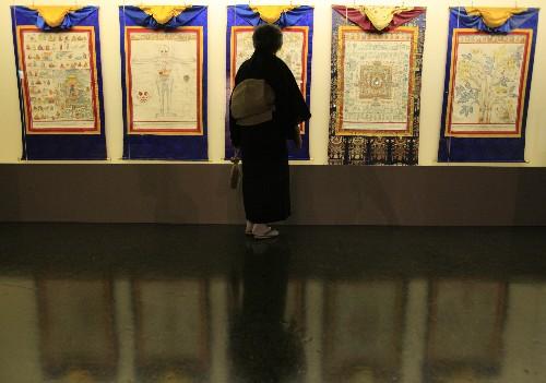 7月11日，观众在日本北海道近代美术馆举行的“圣地西藏珍宝展”上观看关于医学的唐卡。当天，介绍西藏文化艺术的“圣地西藏珍宝展”在北海道首府札幌开幕。展览展出了中国西藏自治区博物馆和布达拉宫等地珍藏的123件珍贵文物，其中包括36件国家一级文物。札幌的展出将持续到8月23日，之后还将在东京、大阪和仙台进行巡回展出。 新华社记者任正来摄