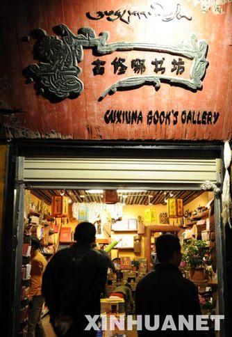 入夜时分，顾客走进古修哪书坊（6月28日摄） 在拉萨老城区八廓街上鳞次栉比的商铺、酒吧和餐吧之中，有一间名叫“古修哪”（藏语意为：请进来坐）的书坊格外引人注目，书坊内出售有涉及西藏文化、旅游等内容的文字图书上千种，已成为不少国内外进藏游客的必去之地。 新华社记者 觉果 摄
