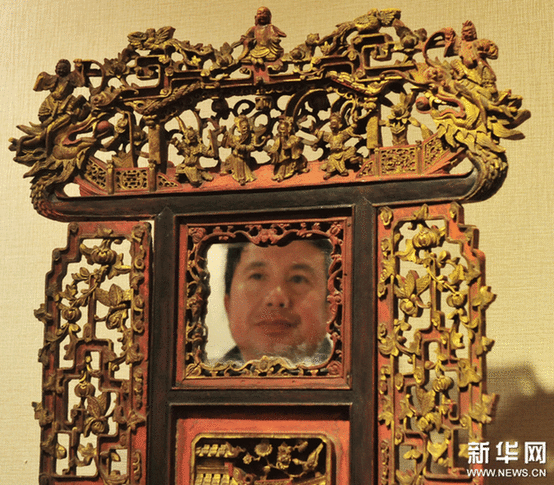 （2）2月9日，一位市民在观看一个工艺繁复的带镜木雕盆架。