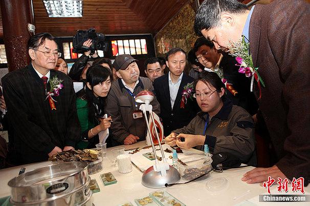 重庆大足石刻千手观音抢救性维修保护工程现场，国家文物局局长单霁翔（右一）现场了解旧金箔的处理程序。
