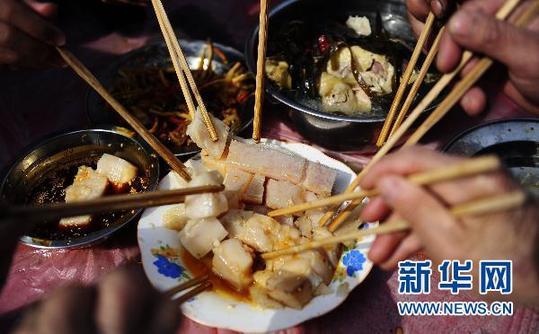 3月7日，在四川省剑阁县锯山村，村民们在享用美味的大肉。新华社记者 江宏景 摄