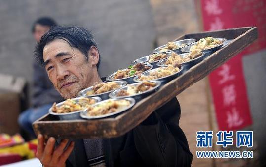 3月7日，在四川省剑阁县锯山村，村民端上美食。新华社记者 江宏景 摄