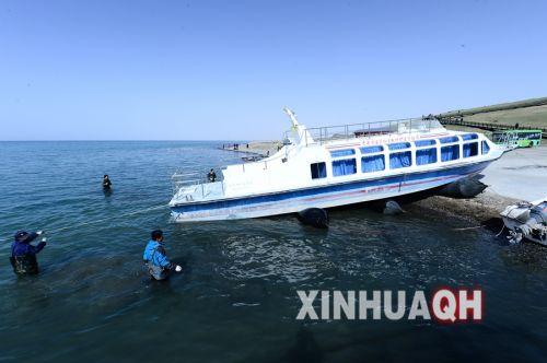 青海湖国家级自然保护区管理局工作人员将监测船拉入水中。新华社　张宏祥　摄