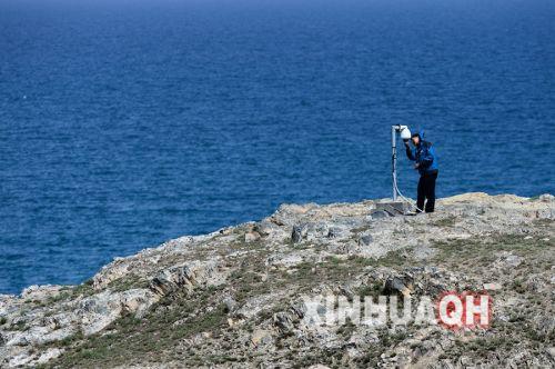 青海湖国家级自然保护区管理局工作人员张虎在青海湖鸬鹚岛区域检查监测探头。新华社　张宏祥　摄