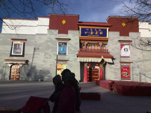 一家三口推着婴儿车走过八廓商城