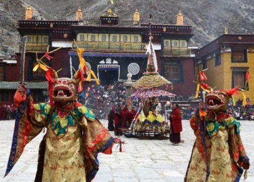 僧人头戴神鹿面具在跳神法会上表演。
