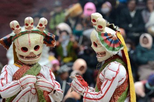 楚布寺两名戴着面具的僧人在跳神法会上表演。