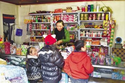 在绕赛二巷的一家小商店里，年轻的老板正在给孩子们卖东西。