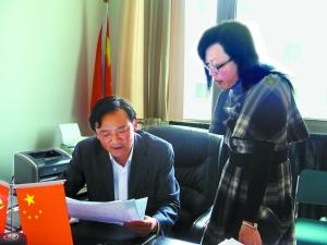 严中易（左）和学校老师讨论工作中的问题。