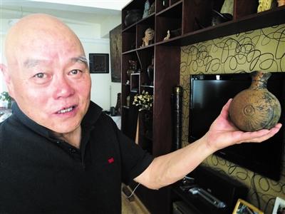 7.2张鹰向记者展示他所收藏的土陶酒壶