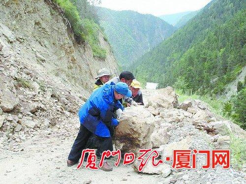 援藏干部下乡调研途中遇到滚石坠落，合力将滚石推开为汽车开道。（肖卫东 供图）