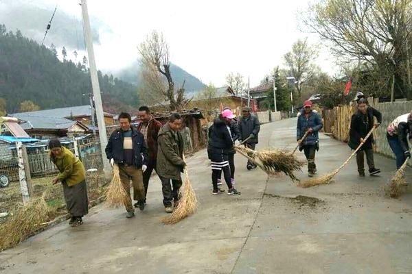 图为嘎朗村村民在打扫村里的环境卫生.jpg