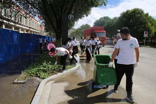 图为员工们正在清理道路两侧的垃圾。.jpg