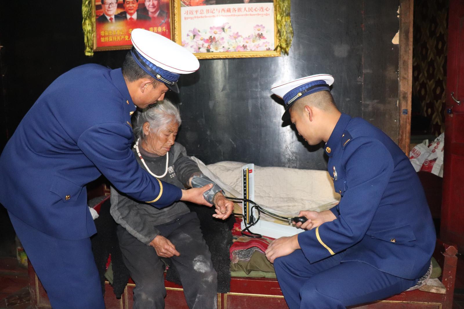 图为中队卫生员阿玉龙为阿妈测量血压.JPG