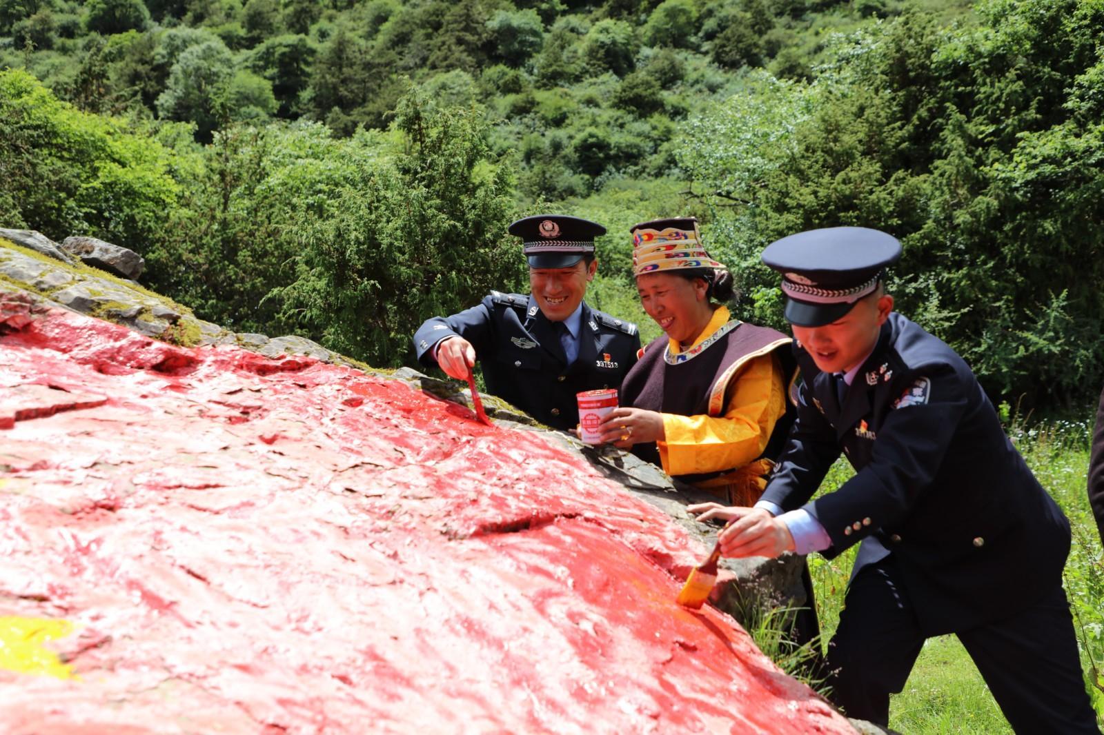 图为玉麦边境派出所民警与群众描绘国旗.JPG