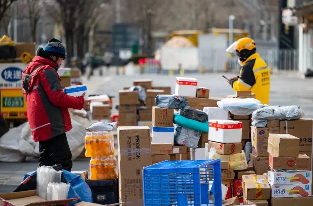 北京市朝阳区望京街道的一个居民小区外，快递员正在整理清点快件 图源：视觉中国